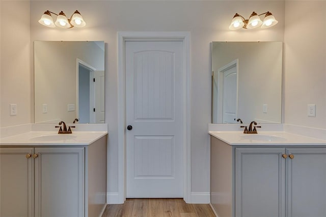 bathroom with two vanities and wood finished floors