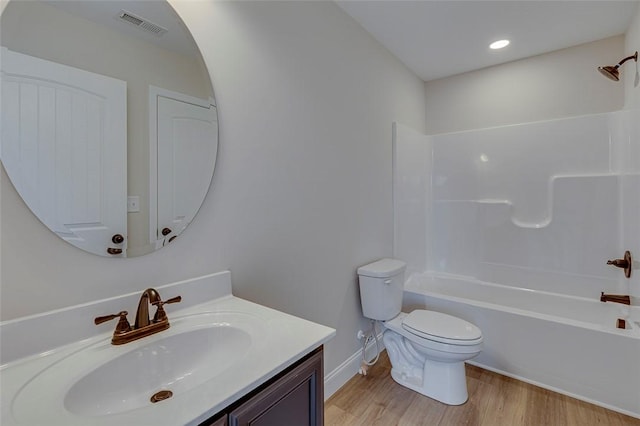 full bathroom with toilet, wood finished floors, vanity, washtub / shower combination, and baseboards