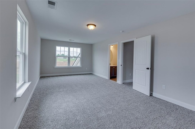 unfurnished room featuring carpet and baseboards