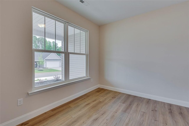 unfurnished room with baseboards and light wood-style floors