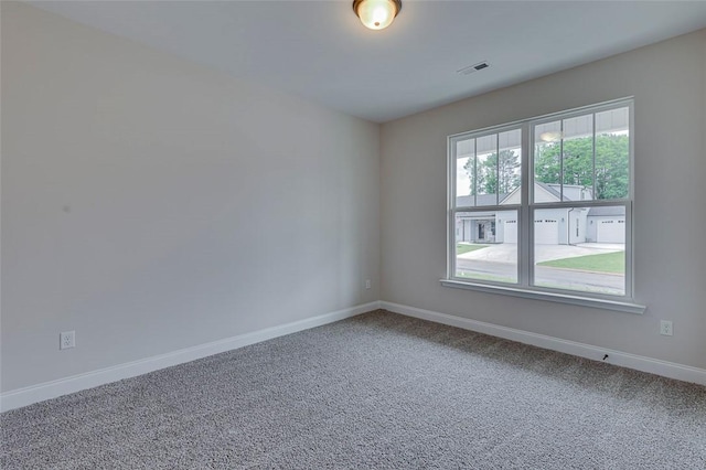 spare room featuring carpet flooring and baseboards