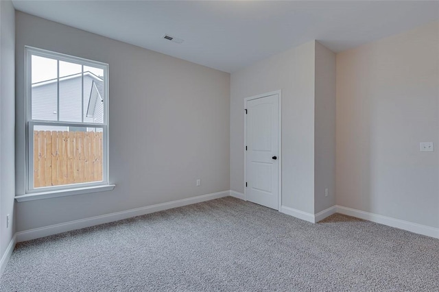 unfurnished room featuring carpet flooring and baseboards