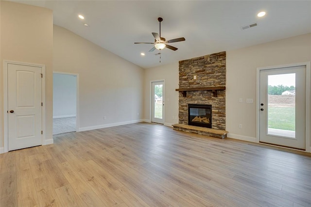 unfurnished living room featuring a ceiling fan, light wood-style floors, a fireplace, vaulted ceiling, and baseboards