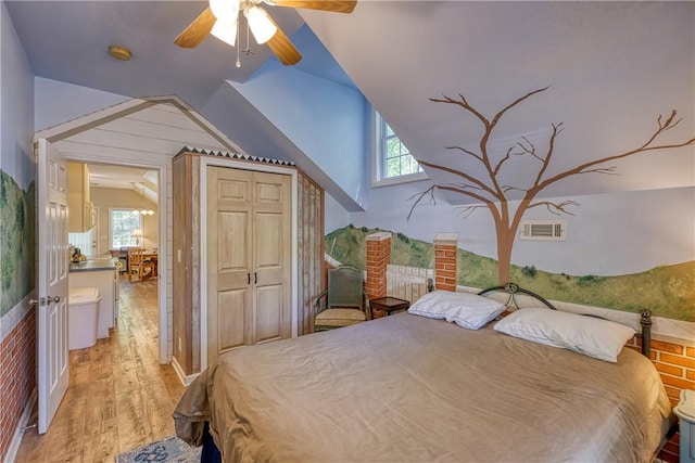 bedroom featuring a closet, light wood-style floors, ceiling fan, lofted ceiling, and visible vents