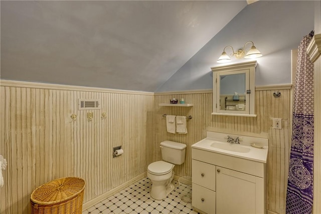 full bath featuring wainscoting, vanity, toilet, lofted ceiling, and visible vents