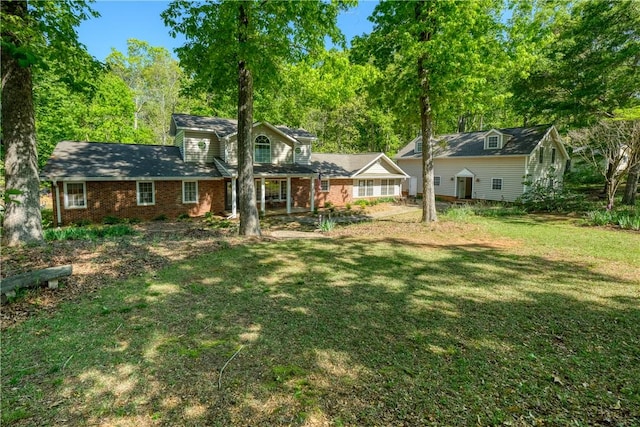 view of front facade featuring brick siding and a front yard