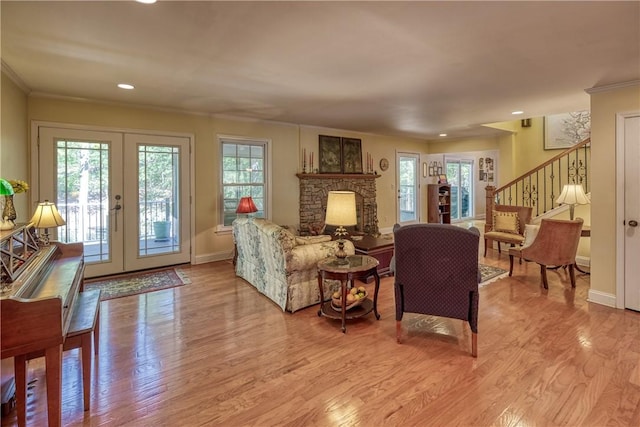 living area with french doors, baseboards, stairway, and a healthy amount of sunlight