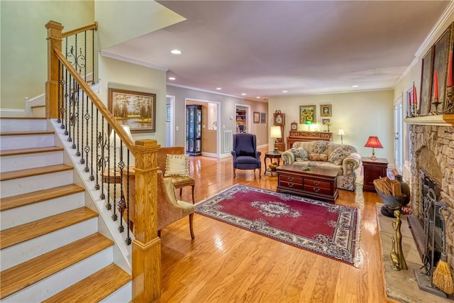 living area with recessed lighting, wood finished floors, stairs, a fireplace, and ornamental molding