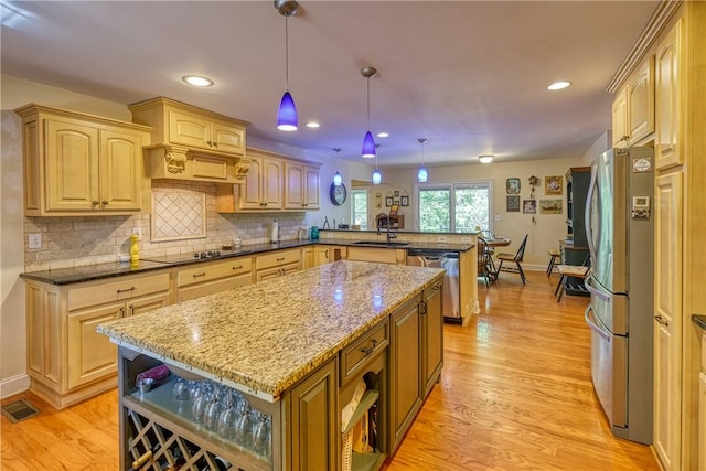 kitchen featuring open shelves, a peninsula, a sink, and appliances with stainless steel finishes