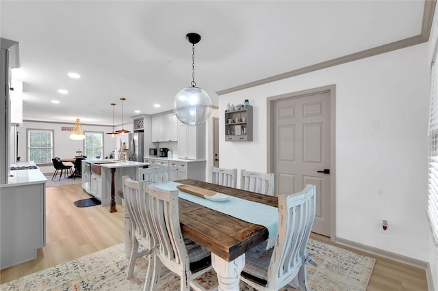 dining room with baseboards, ornamental molding, light wood-style floors, and recessed lighting