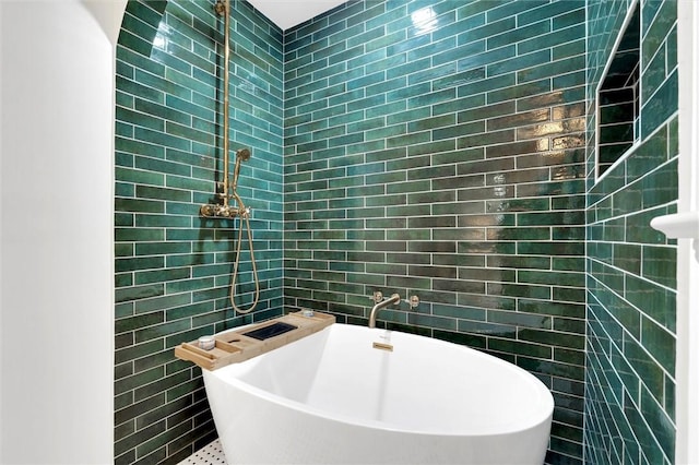 full bathroom with a freestanding tub and tile walls