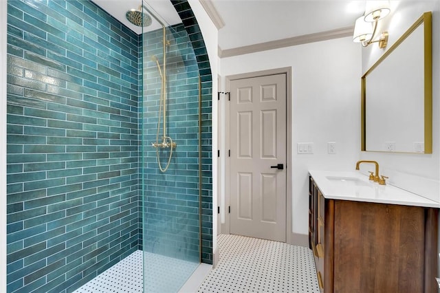 bathroom featuring a tile shower, vanity, and ornamental molding