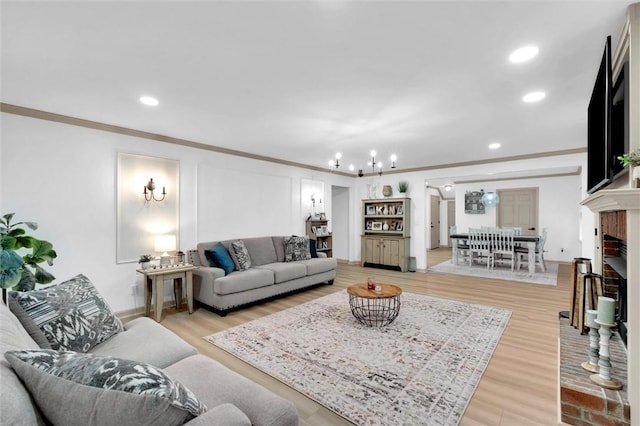 living area with crown molding, a chandelier, light wood-type flooring, and recessed lighting