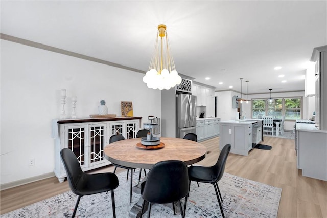 dining room featuring a chandelier, light wood-type flooring, baseboards, ornamental molding, and recessed lighting