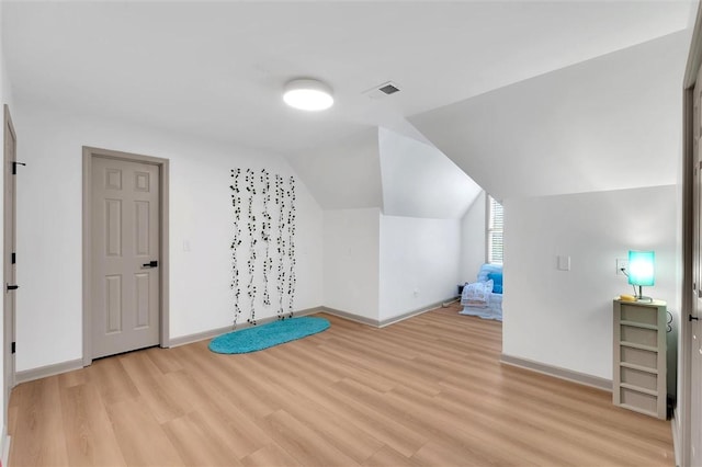 bonus room featuring baseboards, lofted ceiling, visible vents, and light wood-style flooring