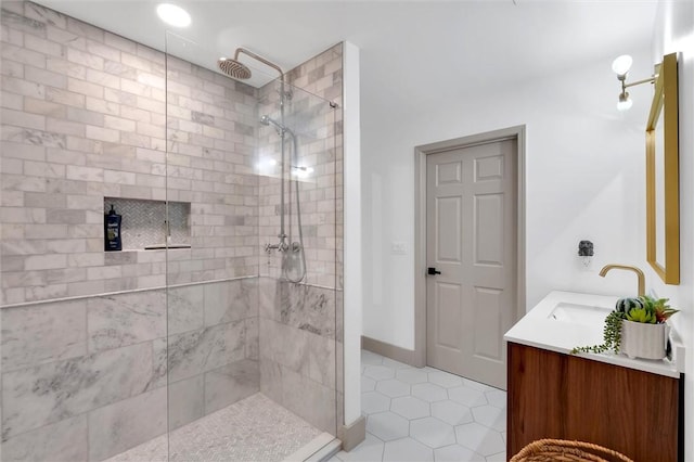 full bathroom with a tile shower, double vanity, tile patterned floors, and a sink