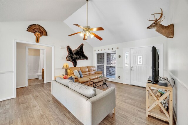 living room featuring lofted ceiling, light wood finished floors, and ceiling fan