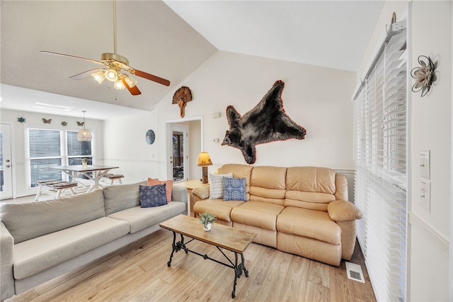 living room with light wood finished floors, vaulted ceiling, visible vents, and ceiling fan