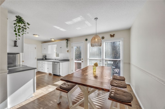 dining area featuring wood finished floors and a textured ceiling