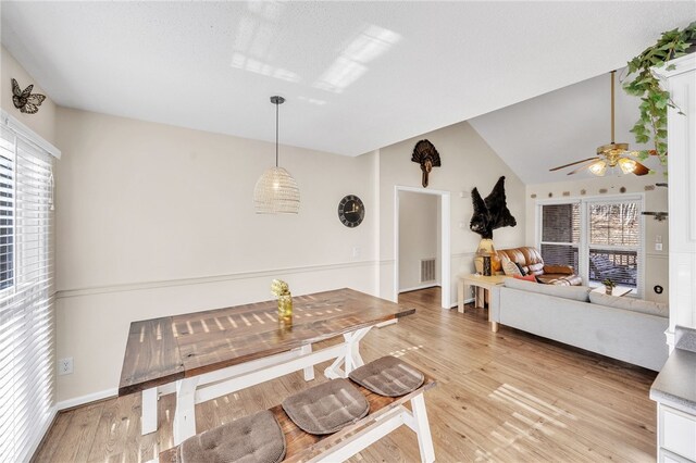 living room with light wood-type flooring, visible vents, and a ceiling fan