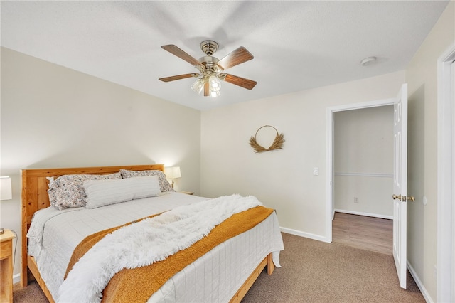 bedroom with ceiling fan, baseboards, and carpet flooring