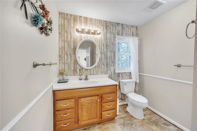 bathroom with visible vents, baseboards, vanity, and toilet