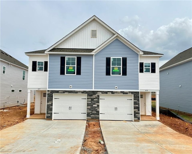view of front of home featuring stone siding, an attached garage, board and batten siding, and concrete driveway