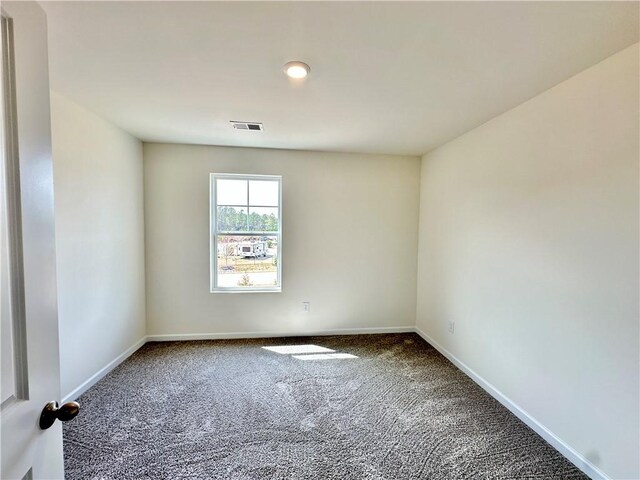 unfurnished room featuring carpet, visible vents, and baseboards