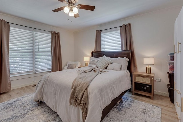 bedroom featuring baseboards, multiple windows, and light wood finished floors