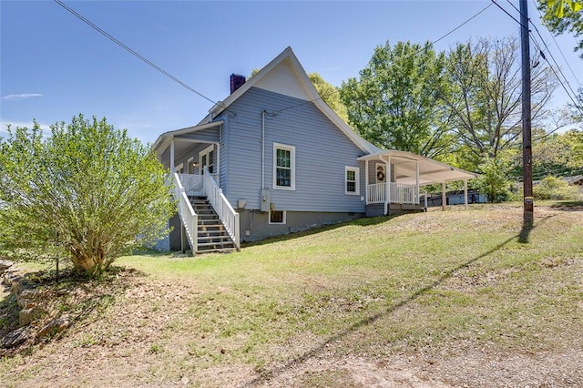 rear view of property featuring a chimney, stairs, and a lawn