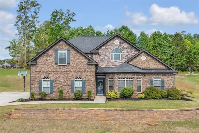 craftsman inspired home with a front lawn, brick siding, and roof with shingles