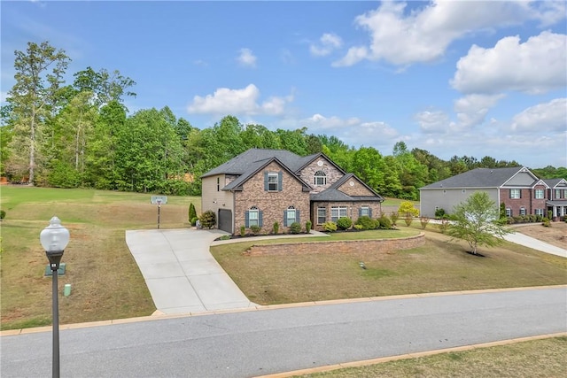 traditional-style home featuring concrete driveway, stone siding, brick siding, a front yard, and a garage