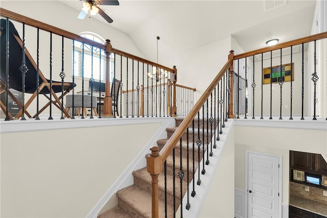 stairway with lofted ceiling, visible vents, and ceiling fan