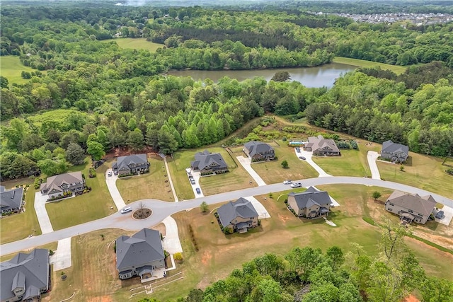 birds eye view of property with a water view, a residential view, and a wooded view