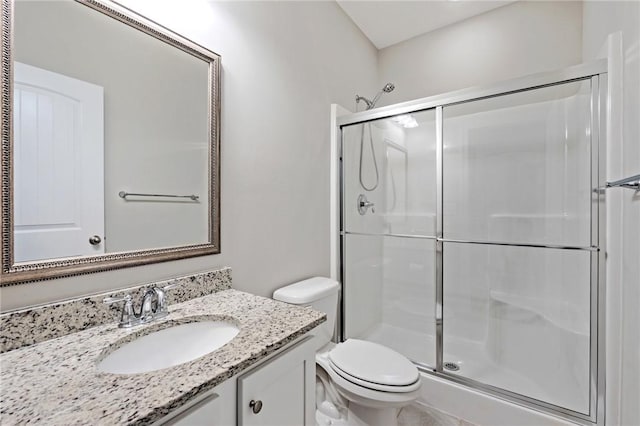 full bath with toilet, vanity, and a stall shower