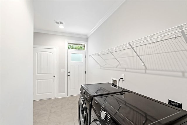 laundry area with washing machine and clothes dryer, crown molding, light tile patterned floors, laundry area, and visible vents