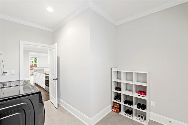 washroom featuring baseboards, laundry area, ornamental molding, and light tile patterned flooring
