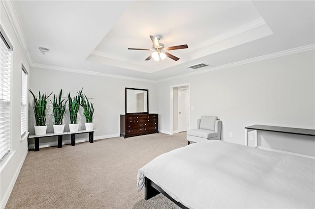 bedroom with baseboards, light carpet, ornamental molding, and a raised ceiling
