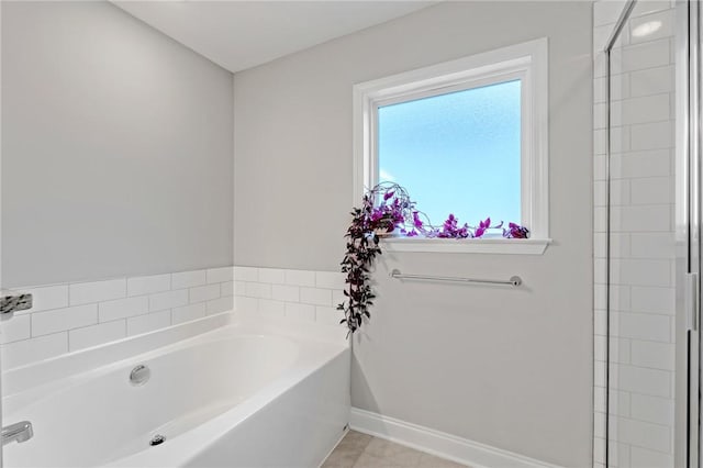 full bath with a garden tub and baseboards