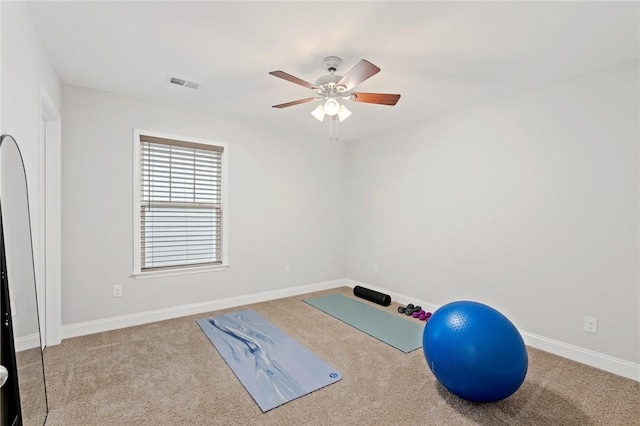 exercise room with baseboards, visible vents, carpet, and ceiling fan