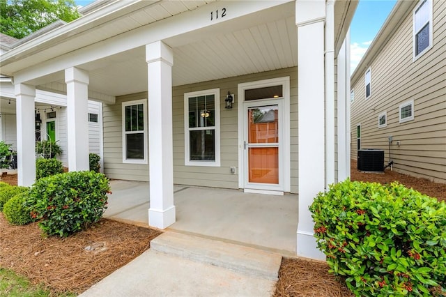 property entrance with covered porch and central AC unit