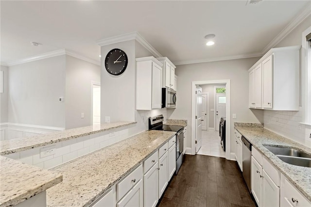 kitchen featuring white cabinets, stainless steel appliances, a sink, recessed lighting, and light stone countertops