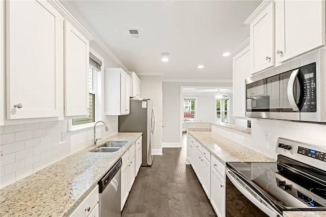 kitchen featuring visible vents, ornamental molding, a sink, appliances with stainless steel finishes, and white cabinetry