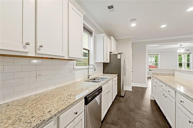 kitchen with white cabinets, stainless steel appliances, visible vents, a sink, and baseboards
