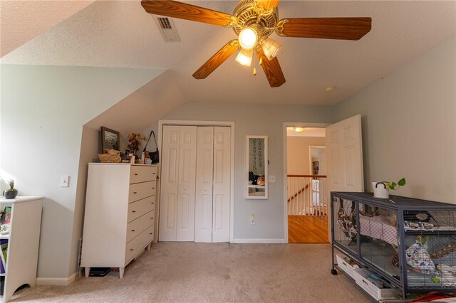 bedroom with ceiling fan, light carpet, visible vents, and a closet