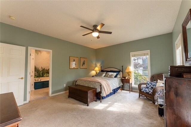 bedroom with light colored carpet, baseboards, a ceiling fan, and connected bathroom