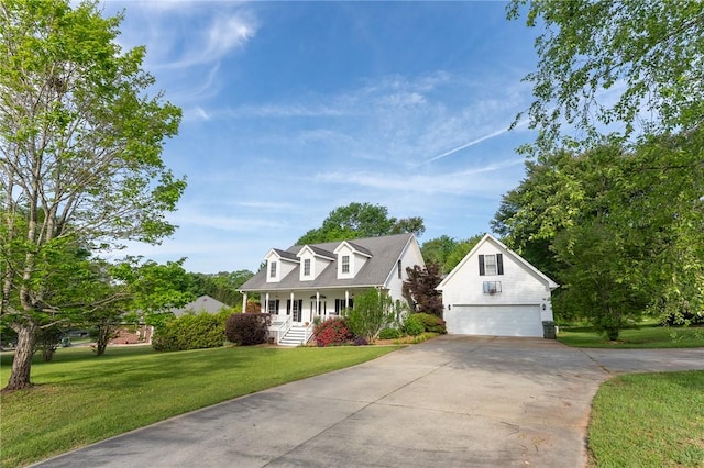 new england style home featuring concrete driveway, a front lawn, a porch, and an outbuilding