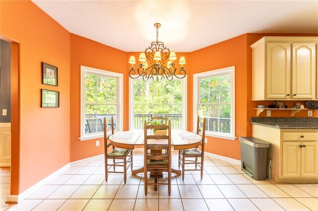 dining space with plenty of natural light, baseboards, a notable chandelier, and light tile patterned flooring