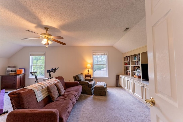 living area with lofted ceiling, visible vents, a ceiling fan, light carpet, and a textured ceiling