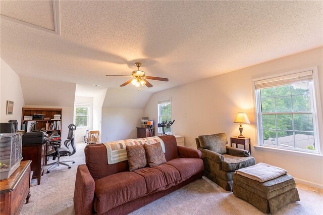 living area with ceiling fan, light carpet, lofted ceiling, and a textured ceiling
